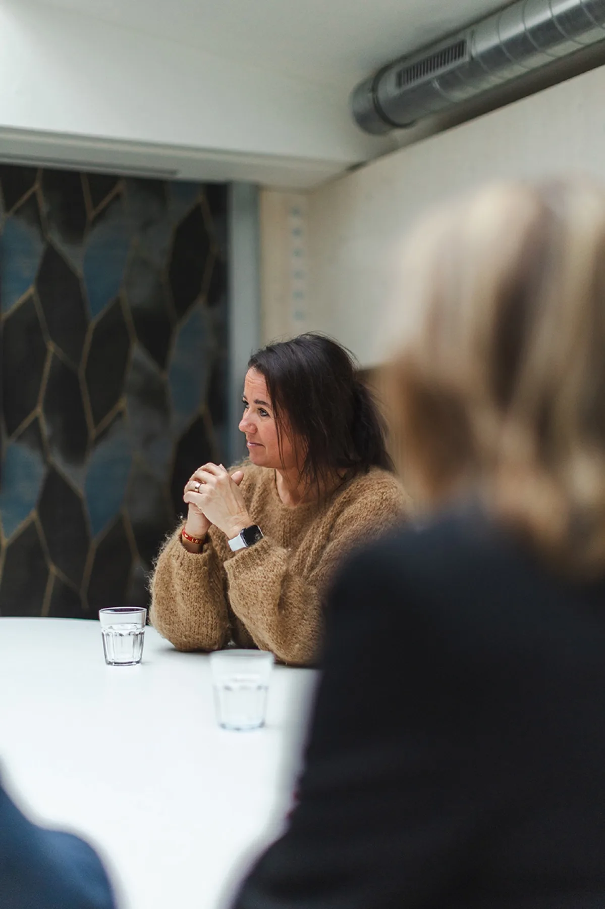 Inge Crezée luistert aandachtig tijdens een gesprek aan tafel